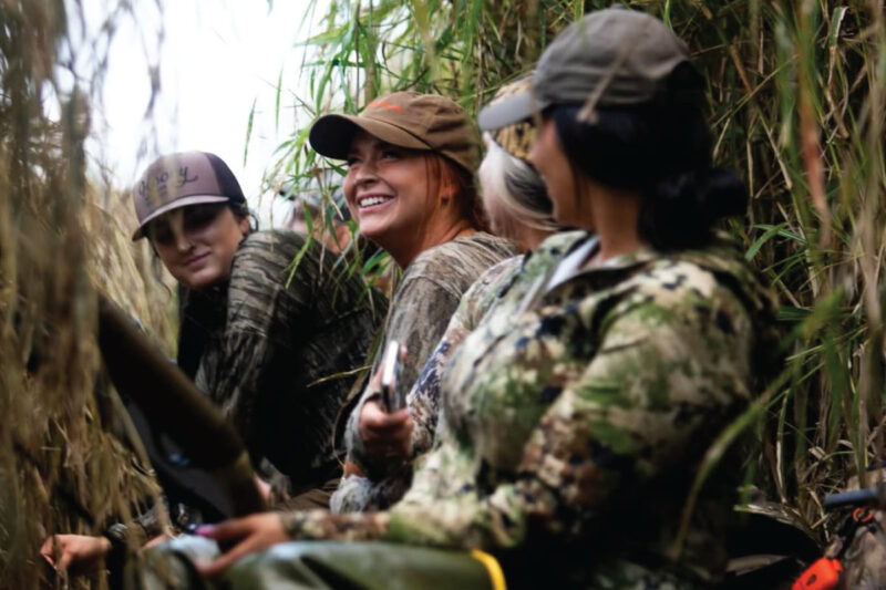 The blend of stillness, calling, and camaraderie in the blind has struck a chord with her. Group of hunters in blind