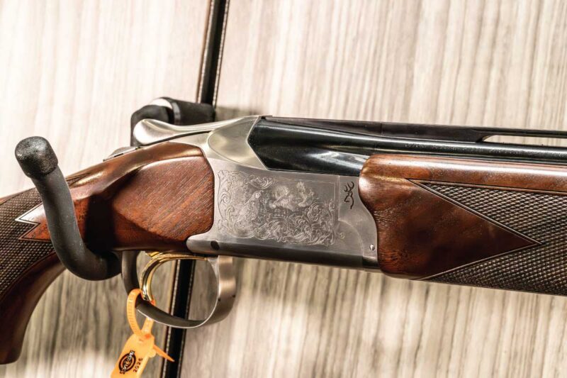 Browning 825 Field model in 12 gauge featuring classic upland game scene engraving.