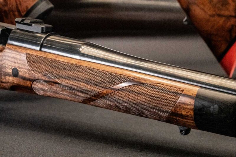 Close-up of the Cooper Model 5200 hand-checkered walnut stock with exhibition-grade wood grain.